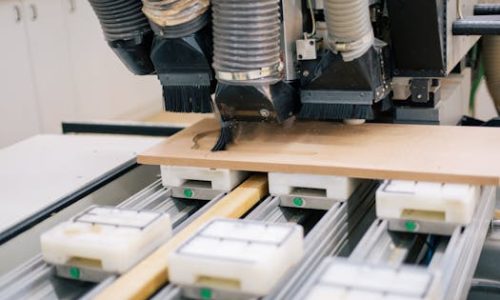 Close-up of a CNC machine carving wood with precision in a workshop setting.