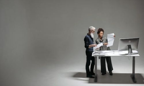 Two professionals analyzing documents and working together at a modern desk.